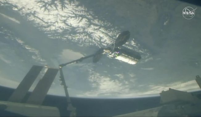 In this image taken from NASA Television, Cygnus capsule arrives at the International Space Station with food galore, following a 1 1/2-day journey from Virginia, Friday, April 19, 2019. Space station astronaut Anne McClain used a robot arm to capture the capsule as they soared 250 miles (402.32 kilometers) above Earth. (NASA TV via AP)