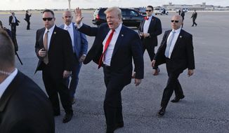 President Donald Trump, center, surrounded by members of the Secret Service, walks across the tarmac to begin to greet supporters during his arrival at Palm Beach International Airport, Thursday, April 18, 2019, in West Palm Beach, Fla. (AP Photo/Pablo Martinez Monsivais)
