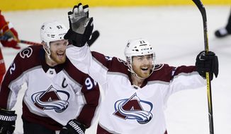 Colorado Avalanche center Colin Wilson (22) celebrates his goal against the Calgary Flames with teammate Gabriel Landeskog (92) during the second period of Game 5 of an NHL hockey first-round playoff series Friday, April 19, 2019, in Calgary, Alberta. (Larry MacDougal/The Canadian Press via AP)