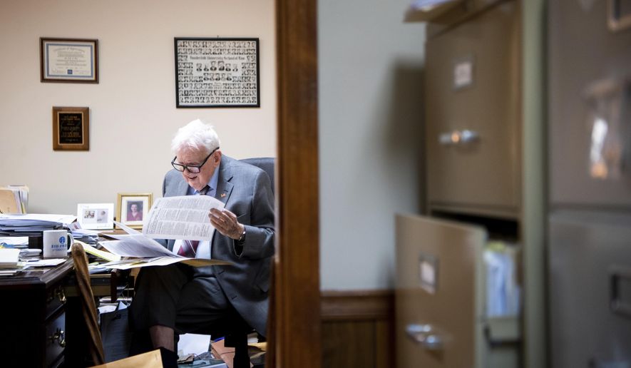 In this March 29, 2019 photo, James L. Bass, 97, studies the Digital Millennium Copyright Act at Bass & Bass Attorneys At Law in Carthage, Tenn. Bass still works five days a week at the family law firm after starting there 70 years ago. Bass served in World War II, went back to school to pursue a law degree and graduated Vanderbilt University School of Law in 1949. (Courtney Pedroza/The Tennessean via AP)