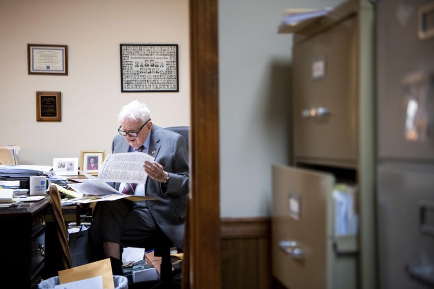 In this March 29, 2019 photo, James L. Bass, 97, studies the Digital Millennium Copyright Act at Bass & Bass Attorneys At Law in Carthage, Tenn. Bass still works five days a week at the family law firm after starting there 70 years ago. Bass served in World War II, went back to school to pursue a law degree and graduated Vanderbilt University School of Law in 1949. (Courtney Pedroza/The Tennessean via AP)