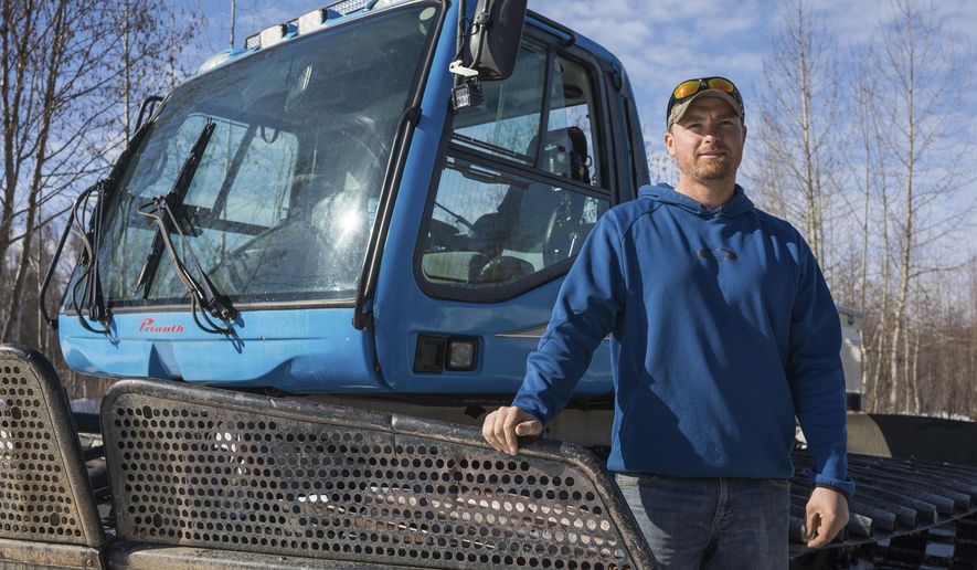 In this Wednesday, April 10, 2019, photo, Bryce Dean, one of the owners of Willow Creek Resort, stands next to a snowcat that he plans to use for ski operations in Hatcher Pass next winter in Willow, Alaska. (Loren Holmes/Anchorage Daily News via AP)