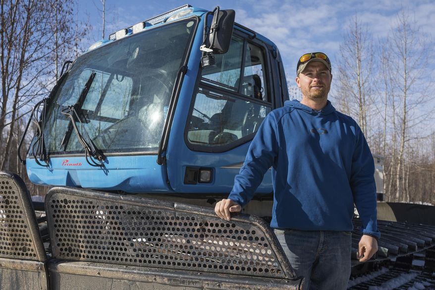 In this Wednesday, April 10, 2019, photo, Bryce Dean, one of the owners of Willow Creek Resort, stands next to a snowcat that he plans to use for ski operations in Hatcher Pass next winter in Willow, Alaska. (Loren Holmes/Anchorage Daily News via AP)