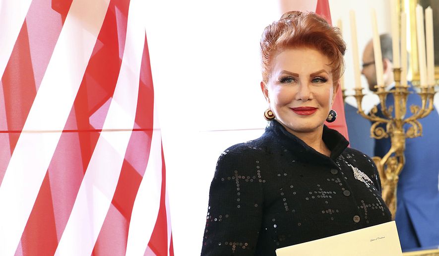 In this Sept. 6, 2018, file photo, Georgette Mosbacher stands next to an American flag after receiving her credentials as new United States ambassador to Poland in Warsaw. Ambassador Georgette Mosbacher wished Jews a happy Passover in Polish, and the reaction has been a wave of angry comments on Twitter. Mosbacher was accused of offending the country with her Passover tweet on Friday, April 19, 2019, and was reminded she serves in a predominantly Roman Catholic country. (AP Photo/Czarek Sokolowski, File)