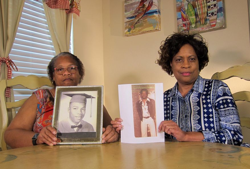 In this Wednesday, April 10, 2019, photo Mylinda Byrd Washington, 66, right, and Louvon Byrd Harris, 61, hold up photographs of their brother James Byrd Jr. in Houston. James Byrd Jr. was the victim of what is considered to be one of the most gruesome hate crime murders in recent Texas history. (AP Photo/Juan Lozano)