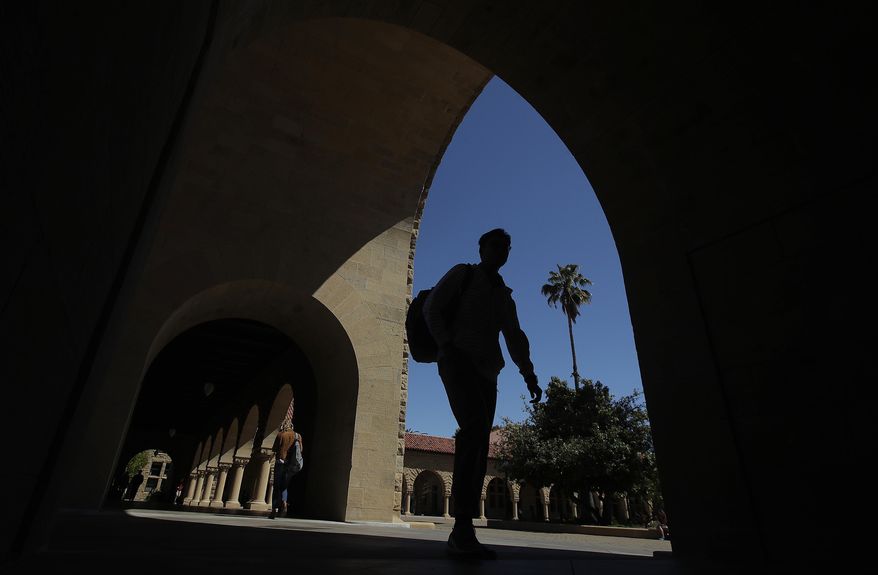 FILE - In this April 9, 2019, file photo, pedestrians walk on the campus at Stanford University in Stanford, Calif. Generally speaking, there are three types of award: free money, such as scholarships and grants; borrowed money, such as loans that need to be paid back; and earned money, such as work study in which you get a work-study job, earn the money and don’t have to repay it. The offer will vary from year to year. (AP Photo/Jeff Chiu, File)
