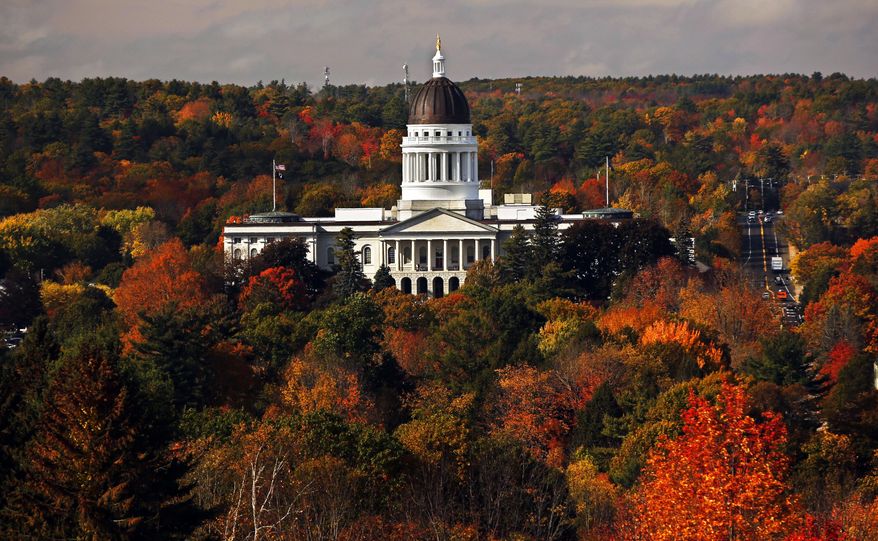 FILE - In this Oct. 23, 2017, file photo, the State House is surrounded by fall foliage in Augusta, Maine. At least 14 Democrats and eight Republican lawmakers in Maine have gone on to register as paid lobbyists in the past three decades, a practice that is being targeted by a bill advancing in the Legislature. The Maine House and Senate last week advanced a bill to ban future lawmakers from any paid lobbying within their first year out of office. The state ethics commissions had called for the change in 2017. (AP Photo/Robert F. Bukaty, File)