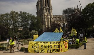 People fix a banner that reads in French: &amp;quot;Notre-Dame is roofless, we too!&amp;quot; during a protest in front of the Notre Dame cathedral in Paris, Monday, April 22, 2019. (AP Photo/Francisco Seco)