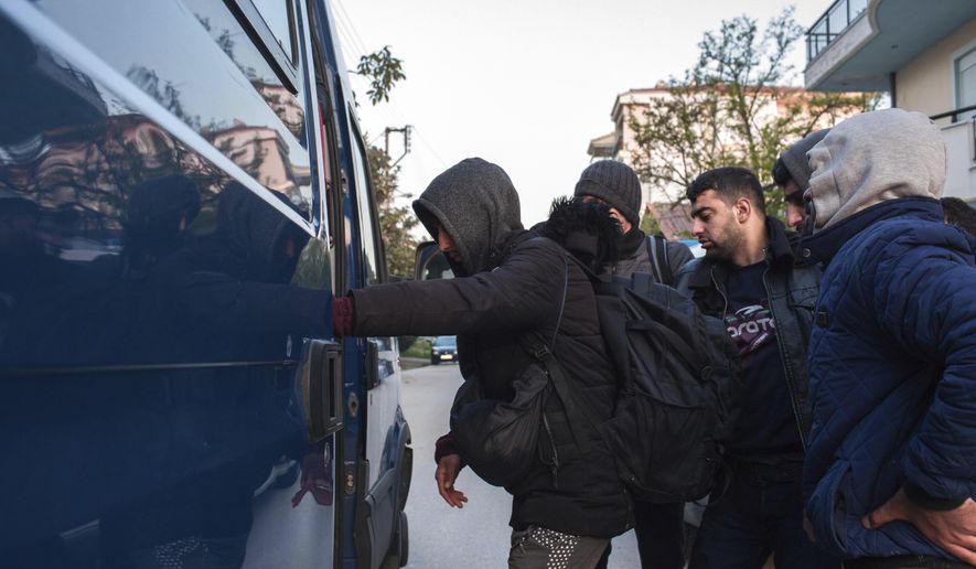 Migrants from Syria and Iraq wanting to register for asylum, embark a police bus in Orestiada town, northeastern Greece, Monday, April 22, 2019. Greek authorities say dozens of asylum-seekers have turned up at the front door of European border agency employees helping police Greece's northeastern border with Turkey. (AP Photo/Antonis Pasvantis)
