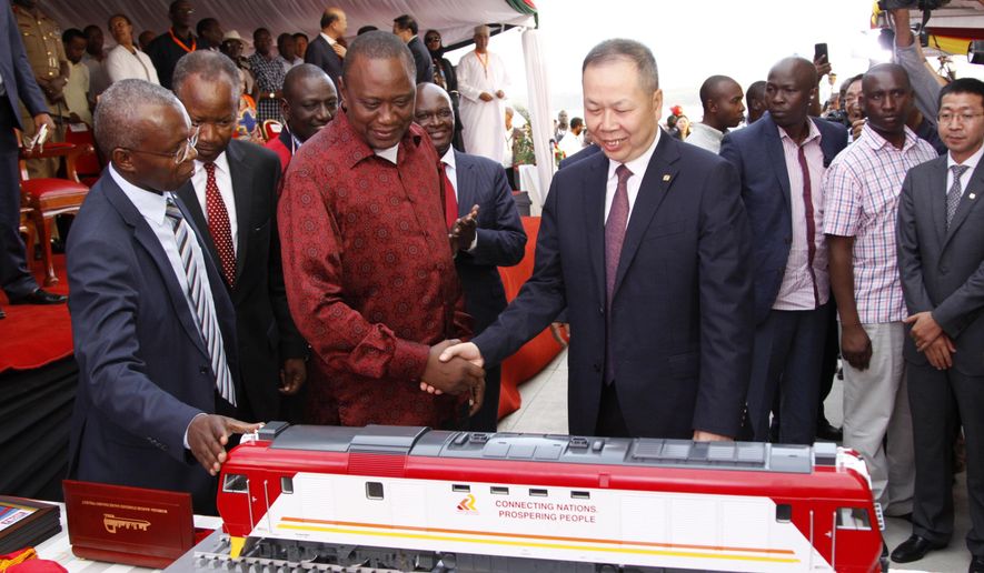 FILE - In this May 30, 2017, file photo, Kenyan President Uhuru Kenyatta, second from left, and Chen Fenjian, president of CCC, shakes hands next to a model of a locomotive during the opening of a Chinese-backed railway costing nearly $3.3 billion, one of the country&#x27;s largest infrastructure project since independence in Mombasa, Kenya. The railway eventually will link a large part of East Africa to a major port on the Indian Ocean as China seeks to increase trade and influence. Asian and African leaders plan to press Beijing at a conference starting Thursday, April 25, 2019, to reduce the politically volatile debt burden left by its Belt and Road Initiative to build ports and other trade-related infrastructure. (AP Photo/Khalil Senosi, File)