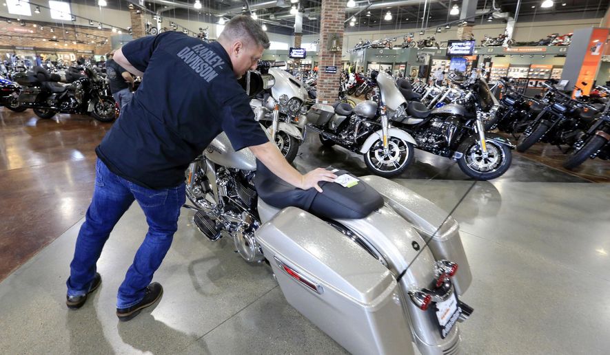 FILE - In this June 26, 2018, file photo, Jason Davis, an employee at the Dillon Brothers Harley Davidson dealership, moves a Street Glide Harley Davidson motorcycle which was sold, at in Omaha, Neb. Harley-Davidson Inc. on Tuesday, April 23, 2019, reported first-quarter earnings of $127.9 million. (AP Photo/Nati Harnik, File)