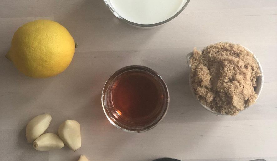 This April 18, 2019 photo shows lemon, left, garlic, honey, milk, a measuring cup and brown sugar displayed in New York. From mincing garlic to making buttermilk, there are certain little tricks that make cooking easier. Others include how to soften brown sugar or how to quickly ripen avocados. (Katie Workman via AP)