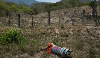 A migrant&#39;s bedding lies on the side of the road after after a group of Central American migrants ran away from Mexican immigration agents on the highway through Pijijiapan, Chiapas state, Mexico, Monday, April 22, 2019. Mexican police and immigration agents detained hundreds of migrants Monday in the largest single raid on a migrant caravan since the groups started moving through Mexico last year. (AP Photo/Moises Castillo)