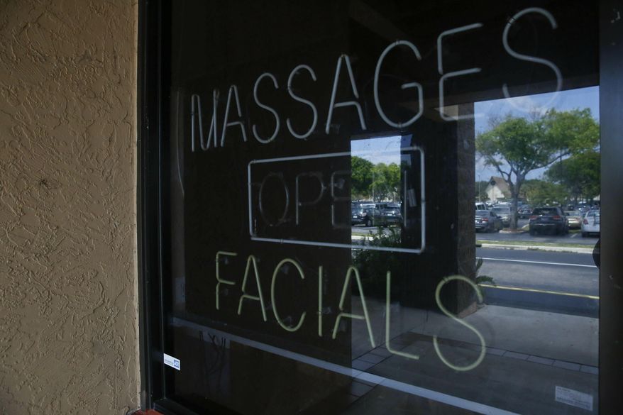 This March 26, 2019 photo, shows the front entrance of the Orchids of Asia Day Spa in Jupiter, Fla. Prosecutors in Southern California said Monday two female massage parlor owners were arrested and charged with pimping out their employees. (AP Photo/Brynn Anderson)