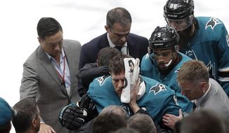 San Jose Sharks center Joe Pavelski, bottom center, is helped off the ice during the third period of Game 7 of an NHL hockey first-round playoff series against the Vegas Golden Knights in San Jose, Calif., Tuesday, April 23, 2019. (AP Photo/Jeff Chiu)