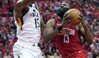 Houston Rockets guard James Harden (13) drives to the basket against Utah Jazz forward Derrick Favors (15) during the first half in Game 5 of an NBA basketball playoff series, in Houston, Wednesday, April 24, 2019. (AP Photo/David J. Phillip)
