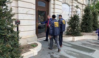 Federal Bureau of Investigation and Internal Revenue Service agents enter City Hall in Baltimore, MD., on Thursday, April 25, 2019. FBI, IRS launched raids connected to Baltimore Mayor Catherine Pugh amid widening probes to determine whether she used sales of her children&#x27;s books to disguise government kickbacks. (Ian Duncan/The Baltimore Sun via AP)