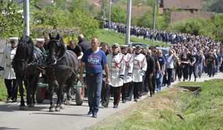 A horse carriage carries the coffin containing the body of Slavisa Krunic during his funeral procession in his home village of Glamocani, outside the northern Bosnian city of Banja Luka, Thursday, April 25, 2019. Thousands of people in Bosnia have attended the funeral of a prominent businessman and government critic who was gunned down this week in a mafia-style ambush. (AP Photo/Radivoje Pavicic)