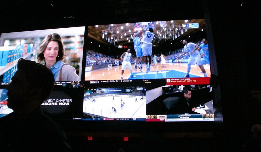 This March 8, 2019 photo shows a fan watching the first day of the March Madness college basketball tournament at the Borgata casino in Atlantic City N.J. Figures released by state gambling regulators on Thursday, April 25, 2019 show more than $106 million was wagered on the NCAA basketball championship tournament in New Jersey _ three times the amount wagered on the Super Bowl. (AP Photo/Wayne Parry)