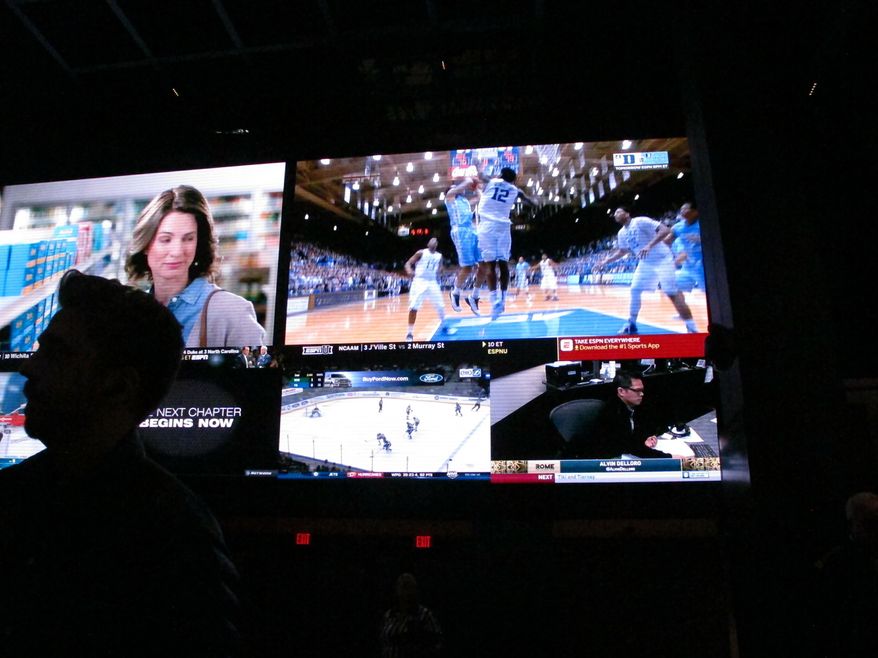 This March 8, 2019 photo shows a fan watching the first day of the March Madness college basketball tournament at the Borgata casino in Atlantic City N.J. Figures released by state gambling regulators on Thursday, April 25, 2019 show more than $106 million was wagered on the NCAA basketball championship tournament in New Jersey _ three times the amount wagered on the Super Bowl. (AP Photo/Wayne Parry)