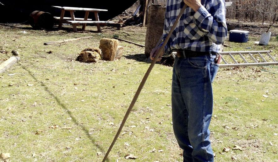 FILE - In this March 14, 2014, file photo, monolingual Cherokee speaker Mack Vann, 83, holds the start of a handmade bow in the backyard of his hime in Briggs, Okla. Vann, among the last members of the Cherokee Nation who spoke and understand the Cherokee language and only the Cherokee language, has died at the age of 88. Nephew Gary Vann says his uncle died Monday, April 22, 2019, in a Tahlequah, Oklahoma, hospital of pneumonia while undergoing treatment of an ongoing heart condition. (AP Photo/Kristi Eaton, File)