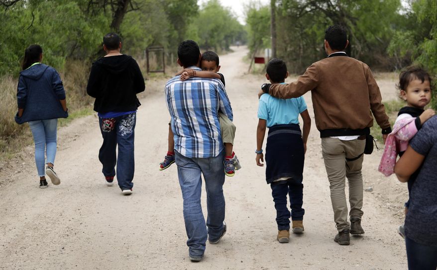 In this March 14, 2019, photo, a group of migrant families walks from the Rio Grande, the river separating the U.S. and Mexico in Texas, near McAllen, Texas, right before being apprehended by Border Patrol. U.S. border authorities say they’ve started to increase the biometric data they take from children 13 years of age and younger, including fingerprints, despite privacy concerns and government policy intended to restrict what can be collected from migrant youth. (AP Photo/Eric Gay) **FILE**
