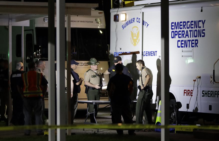 Law enforcement officials work at a command center set up at North Sumner Elementary School Saturday, April 27, 2019, in Bethpage, Tenn. Authorities said they found several bodies in two homes Saturday, prompting a massive manhunt for a possibly armed suspect. (AP Photo/Mark Humphrey)