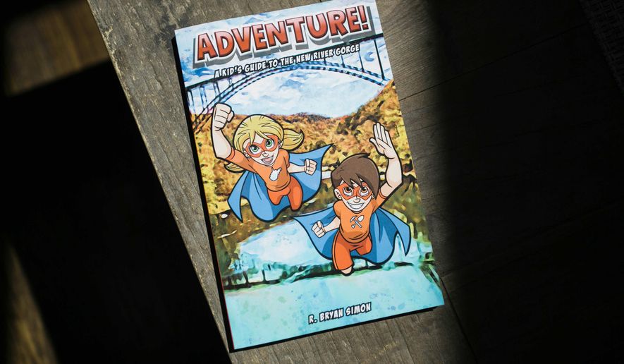 This Tuesday, April 23, 2019 photo shows Bryan Simon's "Adventure: Kids Guide to the New River Gorge" in Fayetteville, W.Va. Simon has written books that aims to get children outside and interested in exploring the New River Gorge. (Chris Jackson/The Register-Herald via AP)