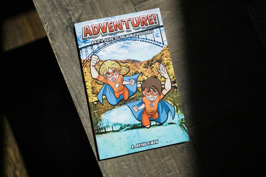 This Tuesday, April 23, 2019 photo shows Bryan Simon's "Adventure: Kids Guide to the New River Gorge" in Fayetteville, W.Va. Simon has written books that aims to get children outside and interested in exploring the New River Gorge. (Chris Jackson/The Register-Herald via AP)