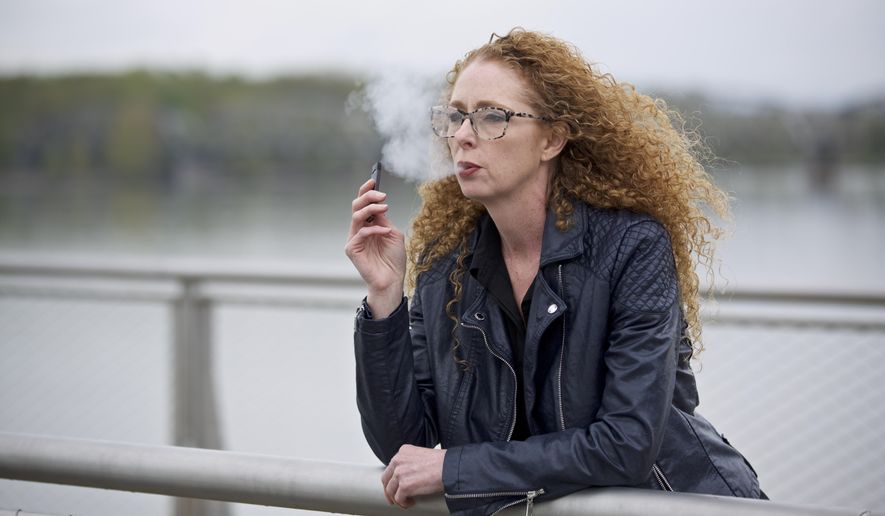 Chantel Williams vapes from a Juul pen in Vancouver, Wash., Tuesday, April 16, 2019. She tried gums, patches and various electronic cigarettes to quit smoking. What finally worked for Williams was the small, reusable e-cigarette that has a strong nicotine punch. (AP Photo/Craig Mitchelldyer)