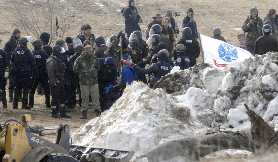 FILE - In this Feb. 23, 2017 file photo, law enforcement enters the Oceti Sakowin camp to begin arresting Dakota Access oil pipeline protesters in Morton County, near Cannon Ball, N.D. Greenpeace is seeking to move a lawsuit in North Dakota state court alleging it conspired against the Dakota Access oil pipeline to federal court, where the environmental group has already prevailed against racketeering claims alleged by the pipeline&#x27;s developer. Greenpeace wants a federal judge to throw out the latest claims of Texas-based Energy Transfer Partners. The company is fighting the effort, maintaining the case belongs at the state court level. (Mike McCleary/The Bismarck Tribune via AP, Pool File)