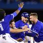 Toronto Blue Jays first baseman Justin Smoak, right, is mobbed by teammates after driving in the winning run against the Oakland Athletics during 11th-inning baseball game action in Toronto, Sunday, April 28, 2019. (Frank Gunn/The Canadian Press via AP)