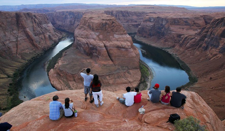 FILE - This Sept. 9, 2011 file photo shows the dramatic bend in the Colorado River at the popular Horseshoe Bend in Glen Canyon National Recreation Area, in Page, Ariz. Parking near the edge of the canyon where the Colorado River turns almost completely unto itself now comes at a cost. Page recently began charging $10 per vehicle at the base of a trail that leads to Horseshoe Bend along the Arizona-Utah border. Officials say it's needed to help control traffic and ensure safety. (AP Photo/Ross D. Franklin, File)