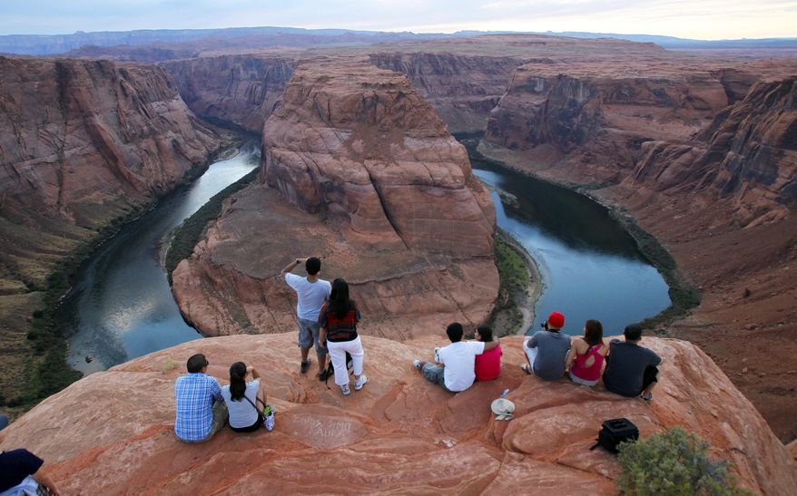 FILE - This Sept. 9, 2011 file photo shows the dramatic bend in the Colorado River at the popular Horseshoe Bend in Glen Canyon National Recreation Area, in Page, Ariz. Parking near the edge of the canyon where the Colorado River turns almost completely unto itself now comes at a cost. Page recently began charging $10 per vehicle at the base of a trail that leads to Horseshoe Bend along the Arizona-Utah border. Officials say it's needed to help control traffic and ensure safety. (AP Photo/Ross D. Franklin, File)