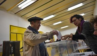 A man casts his vote at a polling station for the general election in Pamplona, Spain, Sunday, April 28, 2019. A divided Spain is voting in its third general election in four years, with all eyes on whether the rise of conservative nationalism will allow the right wing to unseat the incumbent prime minister. (AP Photo/Alvaro Barrientos)