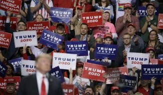 President Donald Trump speaks at a Make America Great Again rally as supporters hold up sign Saturday, April 27, 2019, in Green Bay, Wis. (AP Photo/Mike Roemer)