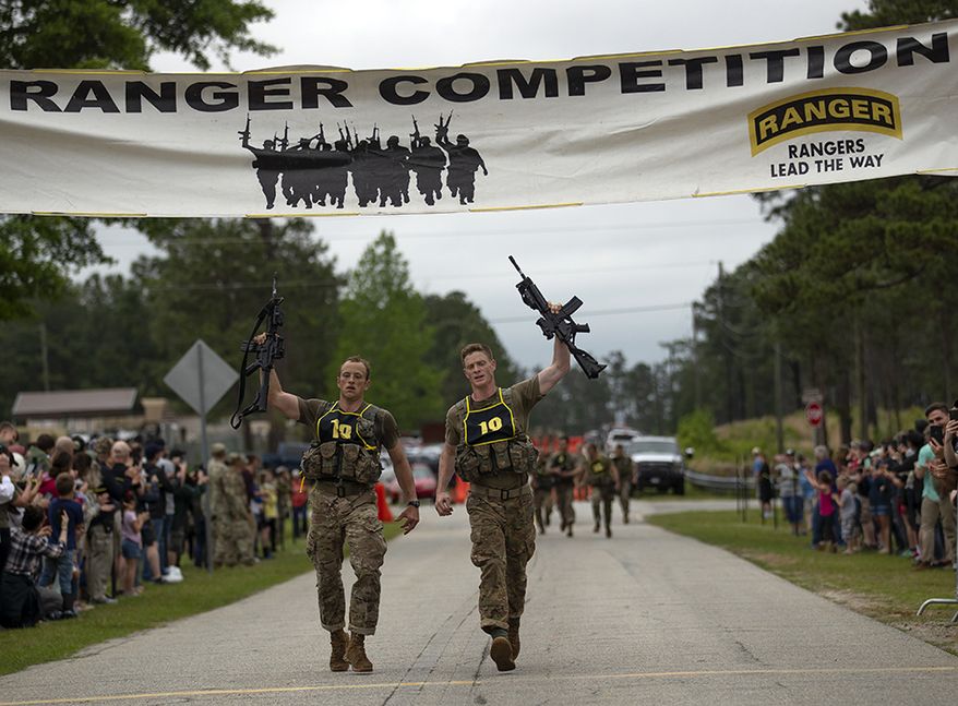 U.S. Army Capts. Michael Rose, left, and John Bergman, both of the 101th Airborne Division, cross the finish line to win the Best Ranger competition Sunday, April 14, 2019, at Fort Benning, Ga. (AP Photo/John Bazemore)