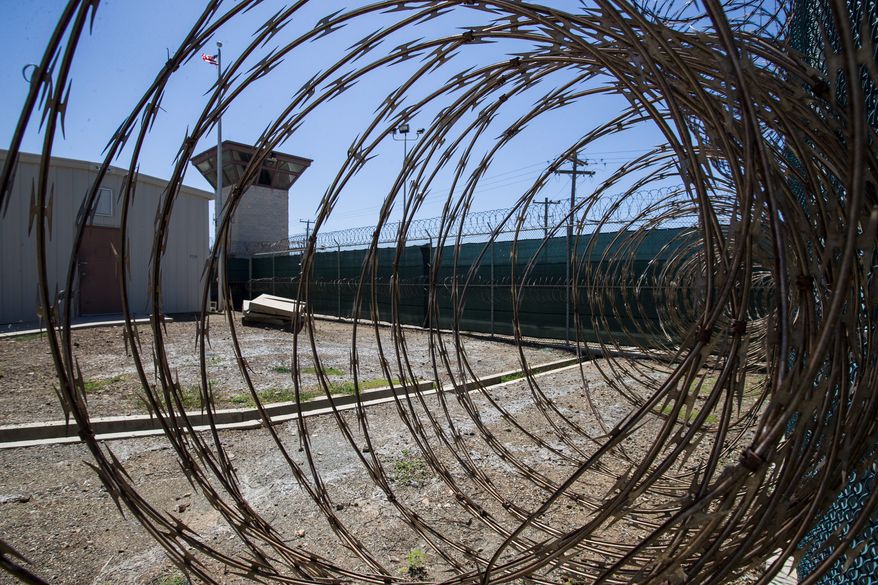 In this photo reviewed by U.S. military officials, the control tower is seen through the razor wire inside the Camp VI detention facility, Wednesday, April 17, 2019, in Guantanamo Bay Naval Base, Cuba. (AP Photo/Alex Brandon)