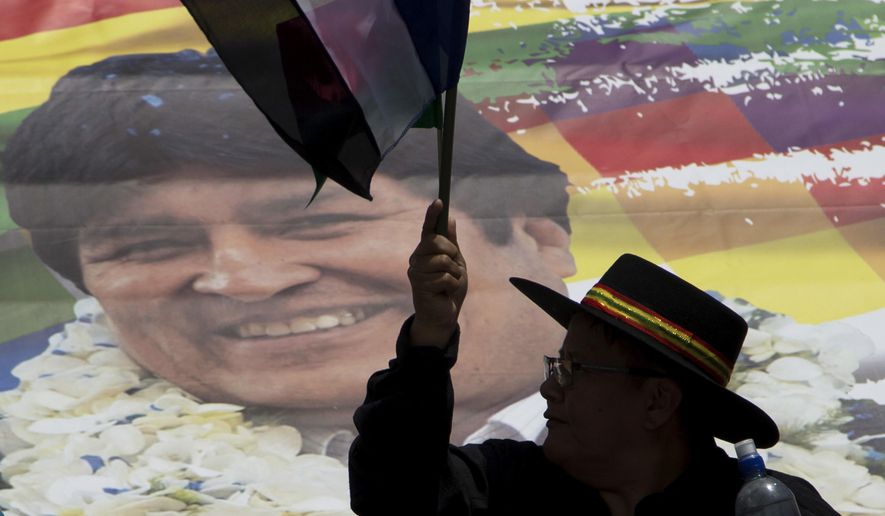 FILE - In this Nov. 7, 2017 file photo, a supporter of Bolivia&#39;s President Evo Morales waves a party flag during a march supporting his re-election, despite a referendum ruling out his run for a fourth term, in La Paz, Bolivia. The prominent human rights group Human Rights Watch says Bolivia has undermined judicial independence by arbitrarily dismissing nearly 100 judges since 2017 and it’s asking the Organization of American States to address the issue. HRW says the judges haven’t been given any reason for the dismissals by a Magistrates Council dominated by Morales&#39; allies. (AP Photo/Juan Karita, File)