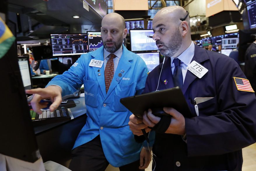 FILE- In this March 18, 2019, file photo specialist Meric Greenbaum, left, and trader Fred DeMarco work on the floor of the New York Stock Exchange. The U.S. stock market opens at 9:30 a.m. EDT on Monday, April 29. (AP Photo/Richard Drew, File)