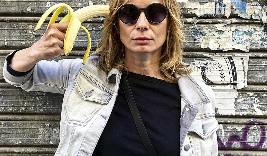 In this photo made 27 April 2019, Polish actress Magdalena Cielecka aims a banana like a gun at her head to protest the removal of an art work from the National Museum in Warsaw that features a woman eating a banana with visible pleasure, which the conservative authorities say is obscene. wld(AP Photo/Dario Salina)