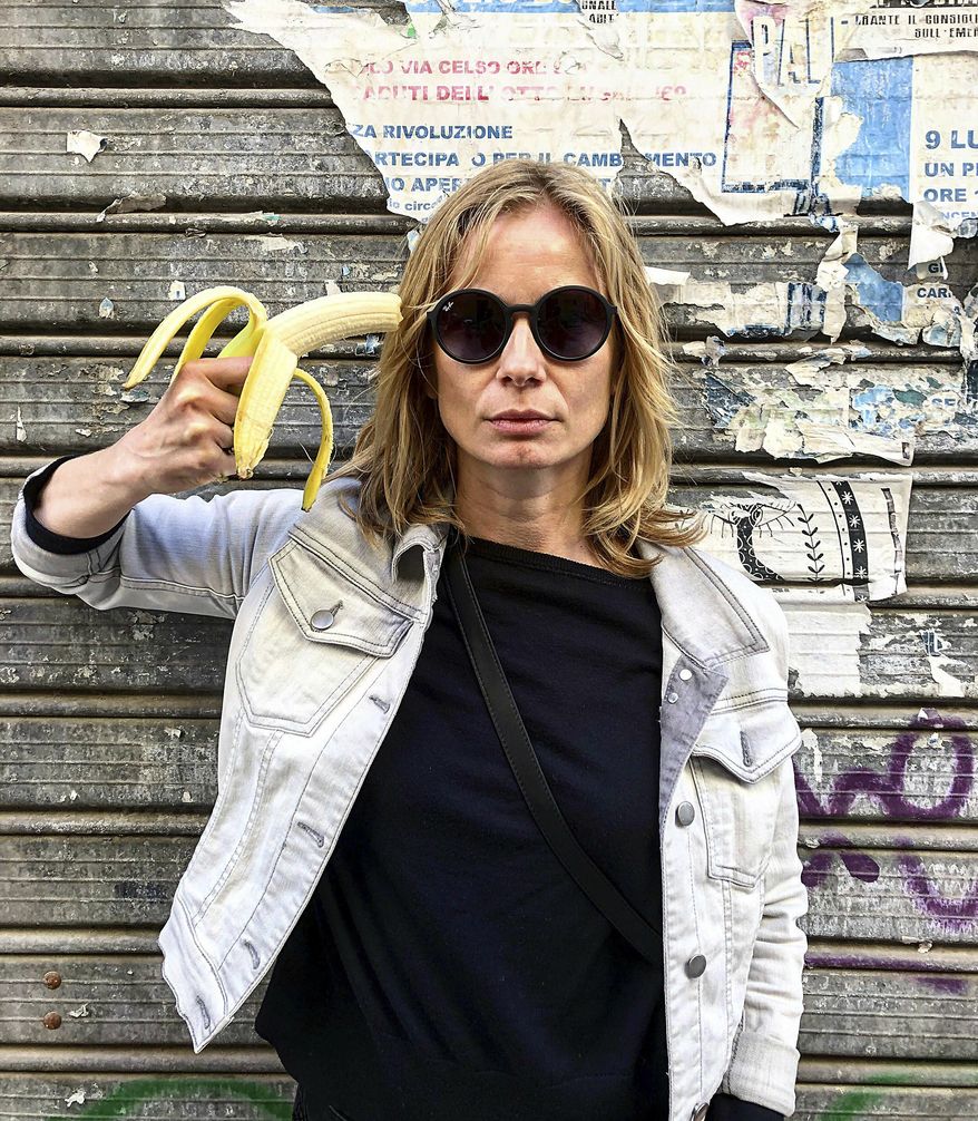 In this photo made 27 April 2019, Polish actress Magdalena Cielecka aims a banana like a gun at her head to protest the removal of an art work from the National Museum in Warsaw that features a woman eating a banana with visible pleasure, which the conservative authorities say is obscene. wld(AP Photo/Dario Salina)