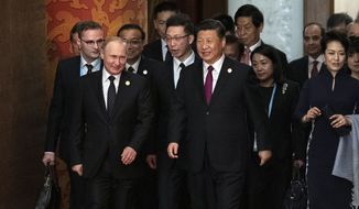 In this April 26, 2019, file photo, Russian President Vladimir Putin, front left, and Chinese Premier Xi Jinping, front center, arrive for the welcome banquet at the Belt and Road Forum at the Great Hall of the People in Beijing. A Russian naval task force has arrived in the northern Chinese port of Qingdao ahead of joint naval exercises that reinforce the growing bond between Beijing and Moscow. (Nicolas Asfouri/Pool Photo via AP, File)