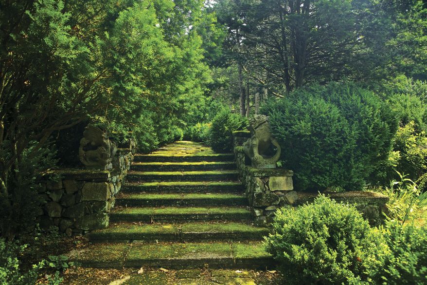 This photo provided by Rizzoli Press shows moss-covered steps guarded by a pair of centuries-old Chinese dragons in Greenwood Gardens, Short Hills, N.J. The photograph is featured in the book "Garden Wild: Wildflower Meadows, Prairie-Style Plantings, Rockeries, Ferneries, and Other Sustainable Designs Inspired by Nature" by Andre Baranowski. (Andre Baranowski/Rizzoli Press via AP)