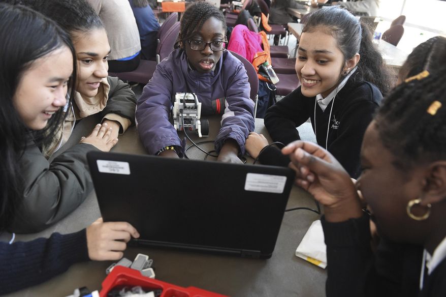 FILE - In this file photo taken Feb. 21, 2019, seventh grade students from Grace Academy in Hartford, Conn., work together on a robot using plans on a computer at the Connecticut Science Center in Hartford. Though less likely to study in a formal technology or engineering course, America's girls are showing more mastery of those subjects than their boy classmates, according to newly released national education data made public Tuesday, April 30, 2019. (Jim Michaud/Journal Inquirer via AP, File)