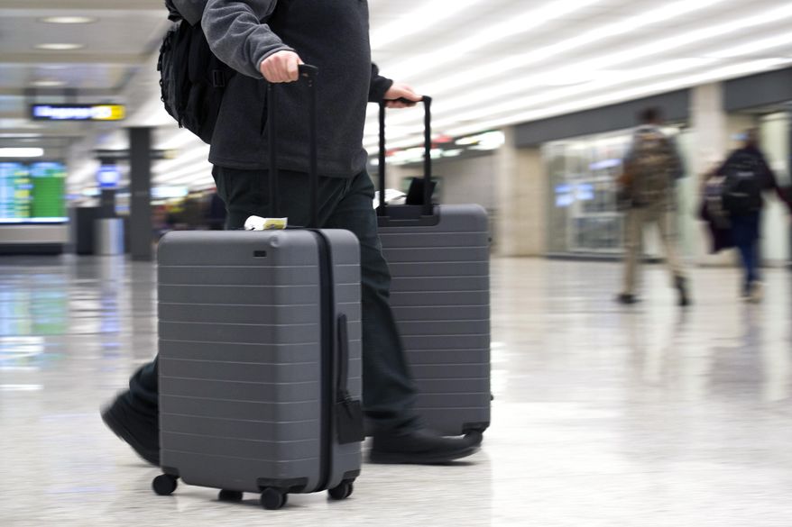 FILE - In this March 26, 2019, file photo, an airline passenger walk in the arrivals terminal at Dulles International Airport in Dulles, Va. Newly documents filed in a federal lawsuit claim that U.S. government searches of phones and laptops at airports are on the rise and are being conducted for reasons beyond immigration and customs enforcement. There were 33,295 searches in fiscal 2018. (AP Photo/Cliff Owen, File)