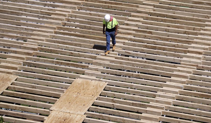 FILE - In this April 9, 2019, file photo a worker walks along the a structure being built for the NFL Draft in Nashville, Tenn. On Wednesday, May 1, the Commerce Department reports on U.S. construction spending in March. (AP Photo/Mark Humphrey, File)