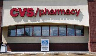 FILE- In this Aug. 7, 2018, file photo a CVS Pharmacy building sign rests on a Jackson, Miss., store. CVS Health reports financial results Wednesday, May 1, 2019. (AP Photo/Rogelio V. Solis, File)