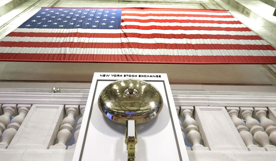 FILE- In this May 17, 2018, file photo an American flag hangs above the bell podium on the floor of the New York Stock Exchange. The U.S. stock market opens at 9:30 a.m. EDT on Wednesday, May 1, 2019. (AP Photo/Richard Drew, FIle)