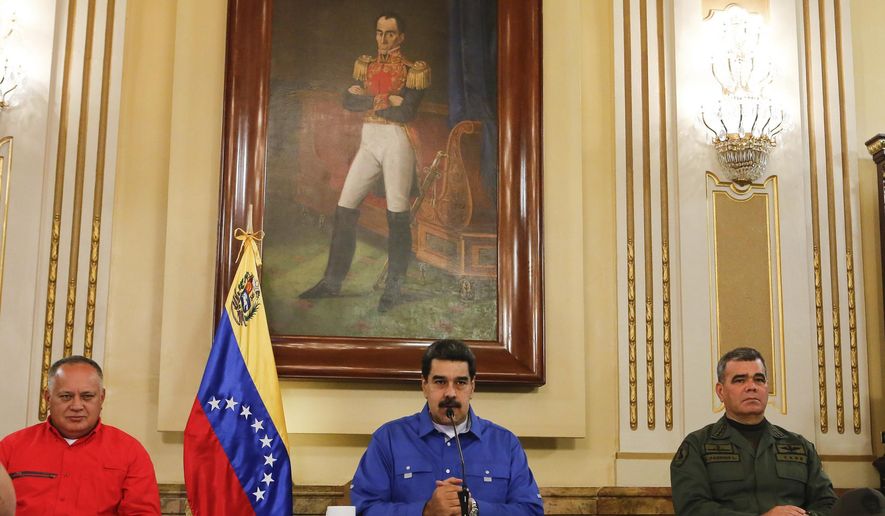 In this photo released by the Miraflores Press Office, Venezuela&#x27;s President Nicolas Maduro, center, flanked by Venezuela&#x27;s Defense Minister Gen. Vladimir Padrino Lopez, right, and the President of the Constituent Assembly Diosdado Cabello, left, speaks during a televised national message at Miraflores Presidential Palace in Caracas, Venezuela, Tuesday, April 30, 2019. Opposition leader Juan Guaidó and jailed opposition leader Leopoldo Lopez took to the streets with a small contingent of armed troops early Tuesday in a call for the military to rise up and oust President Maduro. (Miraflores Press Office via AP)